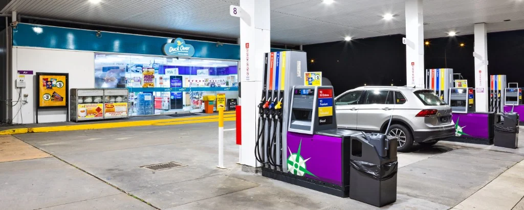 Petrol station forecourt at night with unleaded and diesel fuel pumps