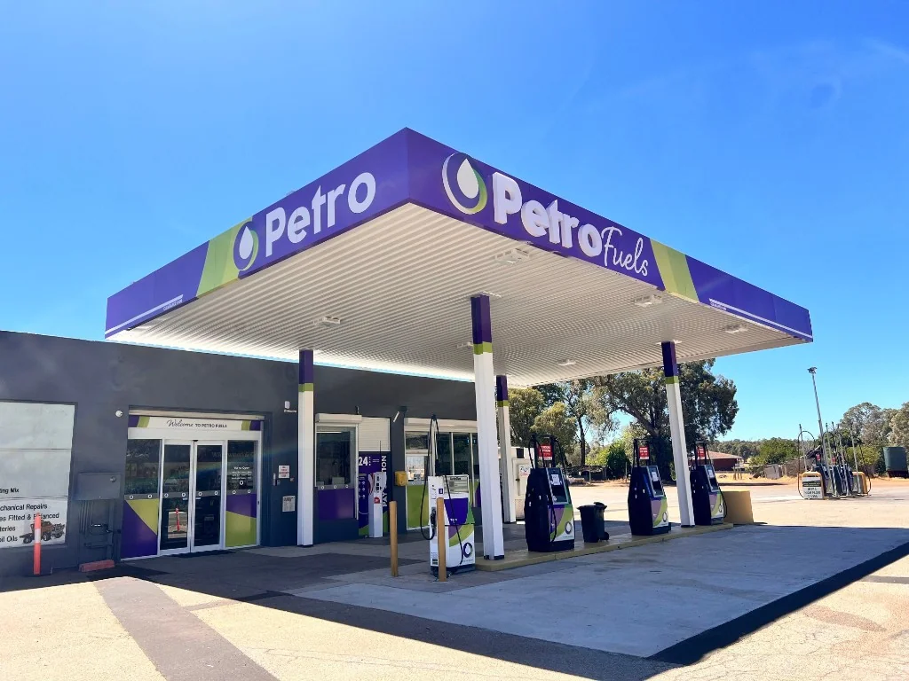 Petro Fuels petrol station with purple canopy, fuel pumps, and mechanical services shop