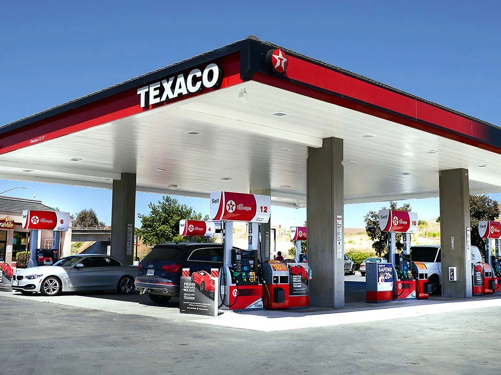 Petrol station at night with premium 98 octane and diesel pumps lit under the canopy