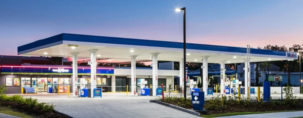 Mobil petrol station with NightOwl convenience store lit at dusk